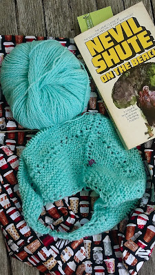 Knitting a striped crescent Reyna shawl and reading On the Beach.