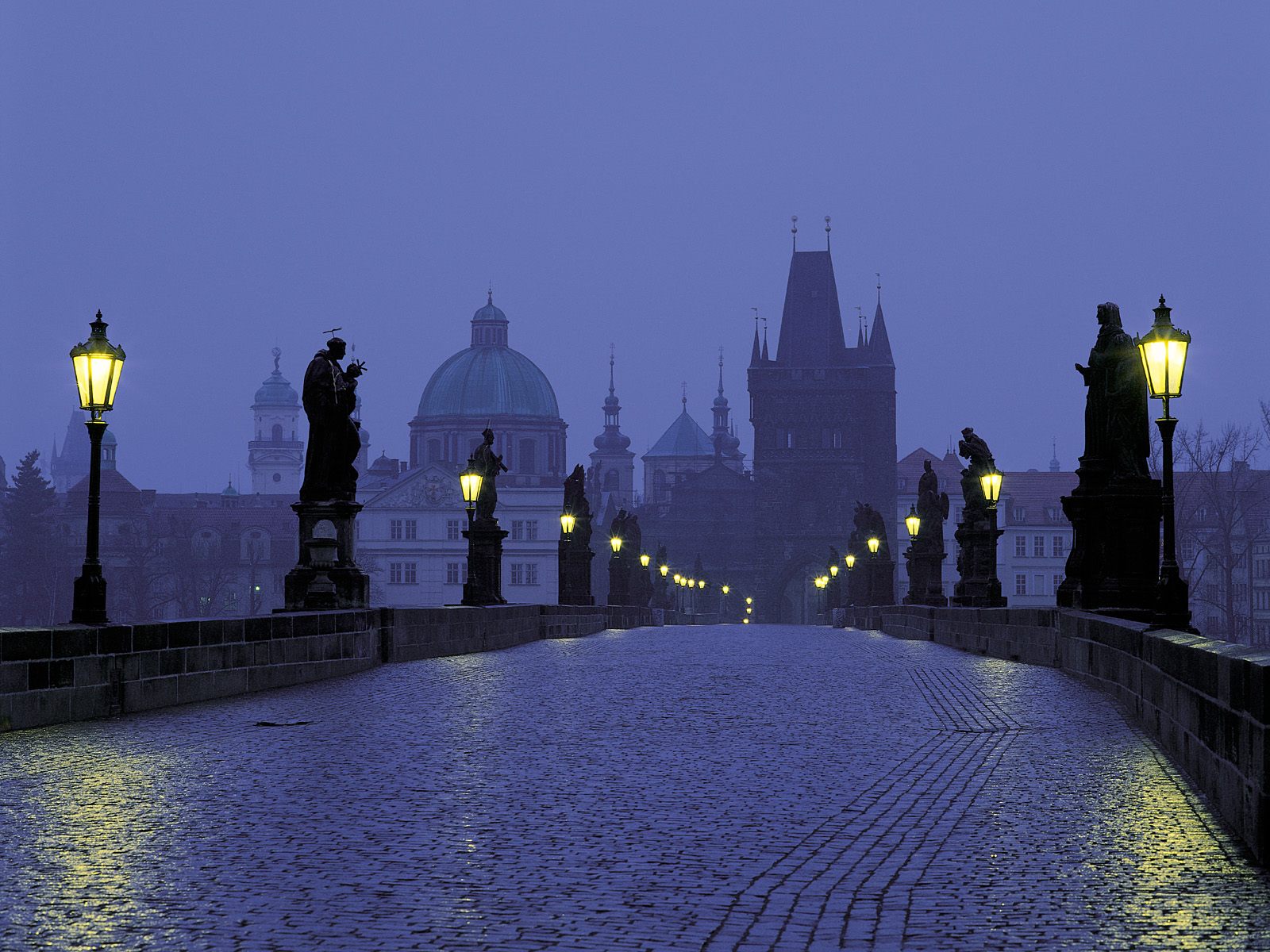 De beroemde Karelsbrug in Praag, vroeg in de morgen met de lichten nog ...