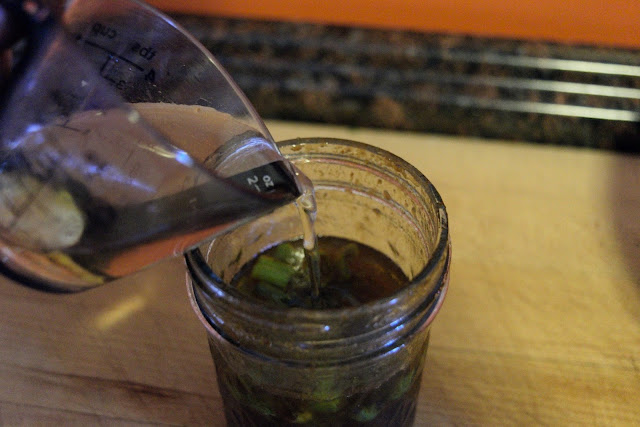 Rice wine vinegar being added to the mason jar for the dressing.