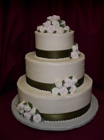 small sugar roses on elegant three tier round white wedding cake