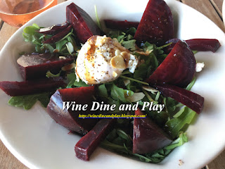 Earthy beets, arugula rocket lettuce, and chèvre goat cheese with almonds makes up this beet salad at Slyce Pizza Bar in Indian Rocks Beach, Florida.