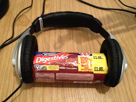 packet of chocolate digestive biscuits wearing headphones 