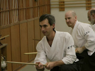 Picture of Jonathan Poppele trainig with a wooden sword to practice relaxed attention.