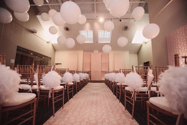 The bride of this wedding decorated her aisle chairs by hot gluing feather