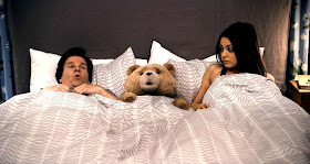 Ted, from the film of the same name, in bed with Mark Wahlberg & Mila Kunis