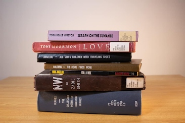 A stack of books by authors like Toni Morrison and Zadie Smith