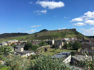 Salisbury Crags under blue skies.