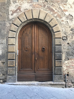 foto de uma porta em arco com decoração de pedra por cima do alisar