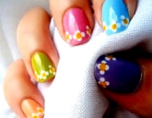 Foto de uñas pintadas de distintos colores con diseños de flores