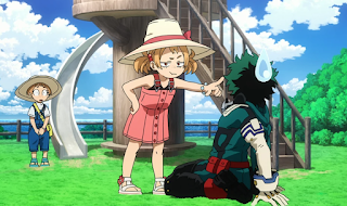 Izuku seated on the ground, Mahoro, a little girl in a straw hat, pointing agressively at him. Her little brother Katsuma is watching behind her and looking nervous.