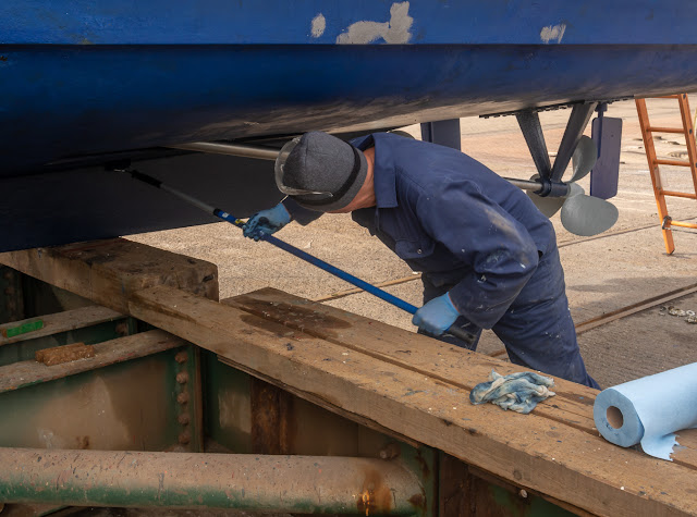 Photo of Phil applying antifoul paint to Ravensdale's hull