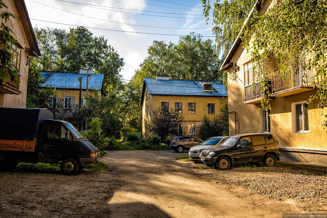 Припаркованные машины у двухэтажных зданий