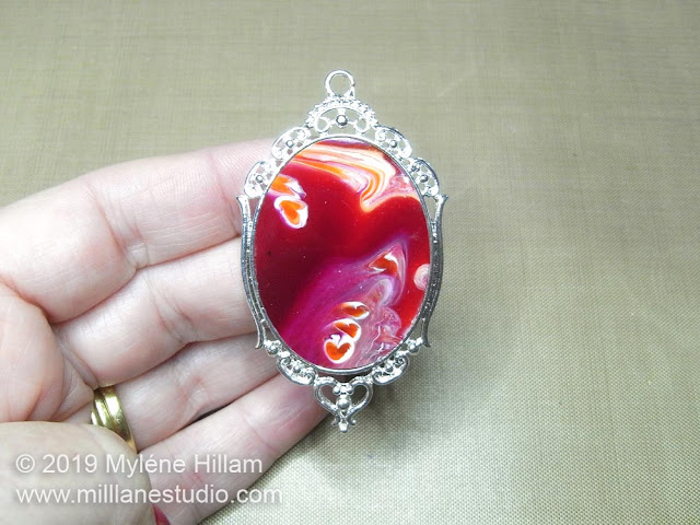 Burgundy and orange marbled resin pendant.