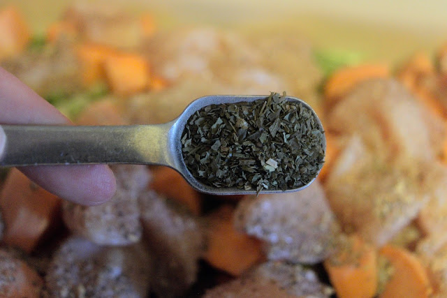 Thyme being added to the baking dish.