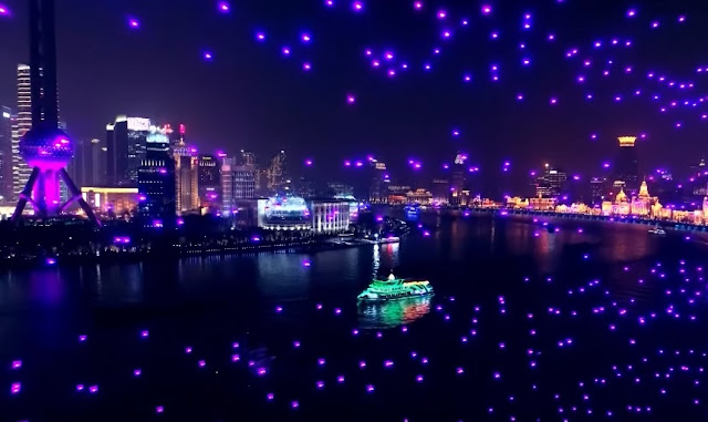 Drones subindo e fazendo milhares de focos de luzes sobre o rio