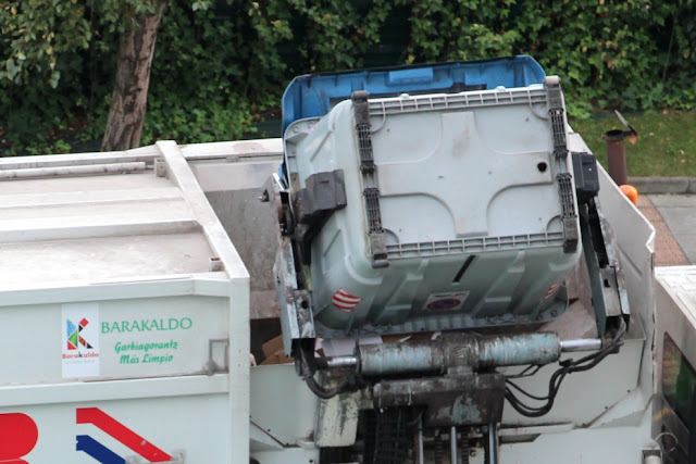 Un camión recoge la basura de un contenedor