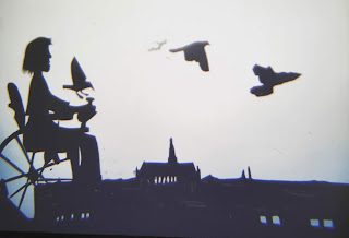 shadow puppetry, figure in wheelchair and skyline of Haarlem, Netherlands