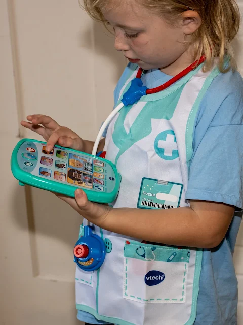 A girl holding the healthcare tablet which comes with the vtech Smart Medical Kit