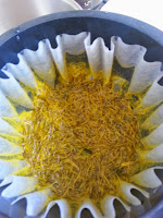 Coffee maker basket filter with dandelion petal and pollen residue.