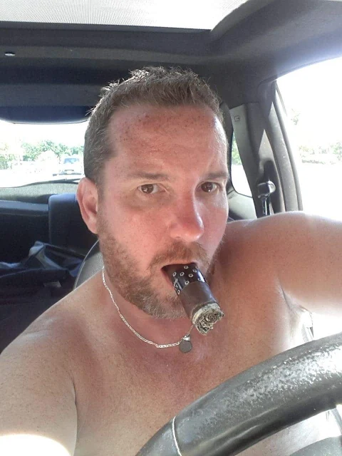 Shirtless cutie pie driving a truck and smoking a cigar