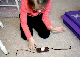 Tessa and I crafted a David and Goliath-style slingshot from a piece of felt and a shoestring. Tessa used cotton balls as stones.