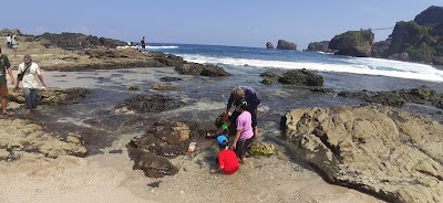 jonadoctor health and business Ayah bermain bersama anak kembarnya di tepi pantai siung , kabupaten gunung kidul provinsi DI Yogyakarta yang banyak tempat Rock climbing  dan pelelangan Ikan laut