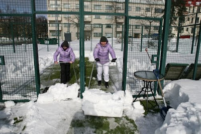 Quitando nieve de la pista de padel