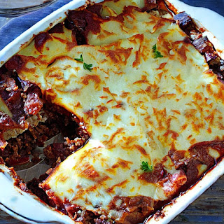 A baked dish made with layers of eggplant or potatoes, ground meat, and béchamel sauce.