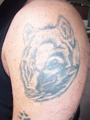 On his left arm he had two tattoos A wolf