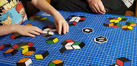 Family playing Rubik's Match card game at coffee table