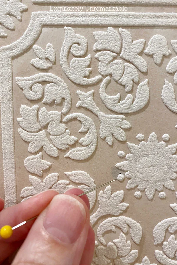 Poking A Hole Through Wallpaper with a pin