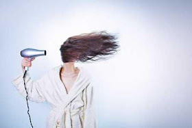 Woman blowing her hair with a hair dryer