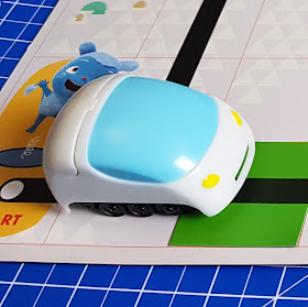 self-driving Oki-doodle car close up White car with blue 'windscreen' and caterpillar track wheels