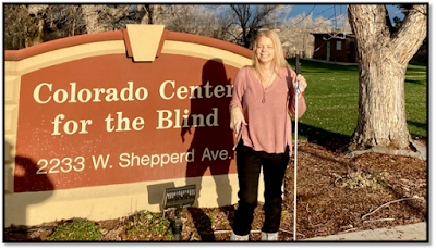 Maureen Nietfeld standing in front of the Colorado Center for the Blind sign in front of the building