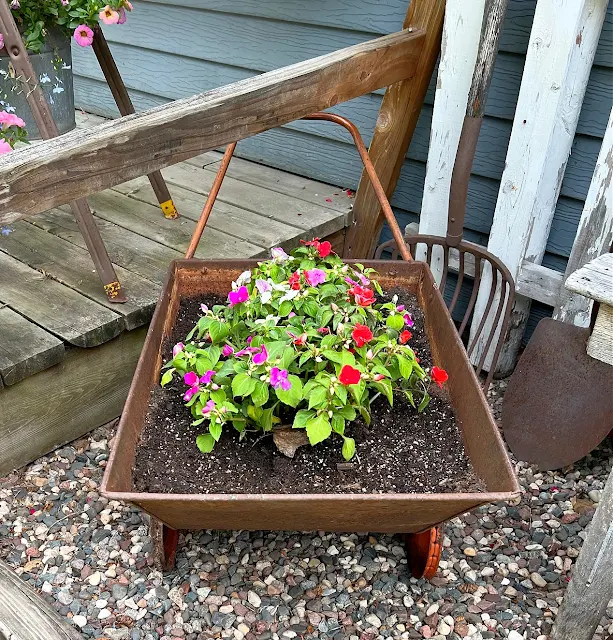 Photo of a vintage garden cart planted with impatiens.