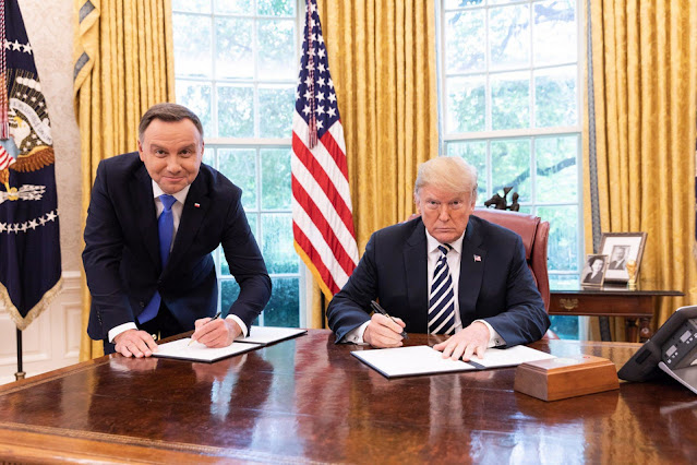 Prezydent Donald Trump i Prezydent Andrzej Duda  podpisują umowę przy biurku