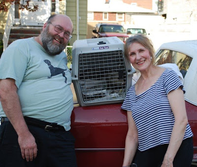 Mike Sylwester and Zofija Sylwester posing with cage holding an opossum.