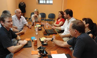 Sentados en una mesa entre comerciantes discutiendo el desarrollo del proyecto