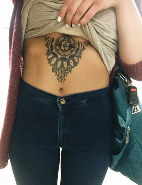Chica tatuada con un mandala en el abdomen
