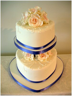 White and pink two tier wedding cake with heart pattern and heart cake 