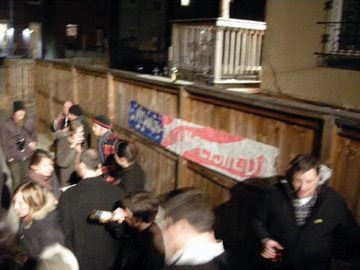 backyard crowed with Mission Accompished banner on a wooden fence