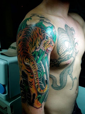 Dragon Tattoo A man with black dragon tattoo on his chest and tiger tattoo 