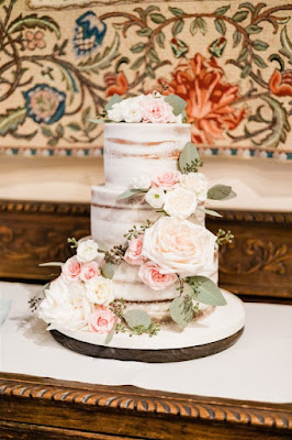 three tier white naked wedding cake with ivory and pink floral