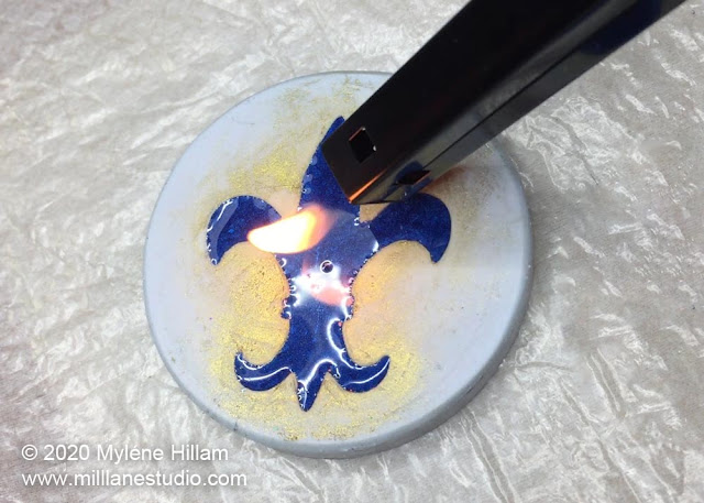 Passing a flame from a BBQ torch across the surface of the resin