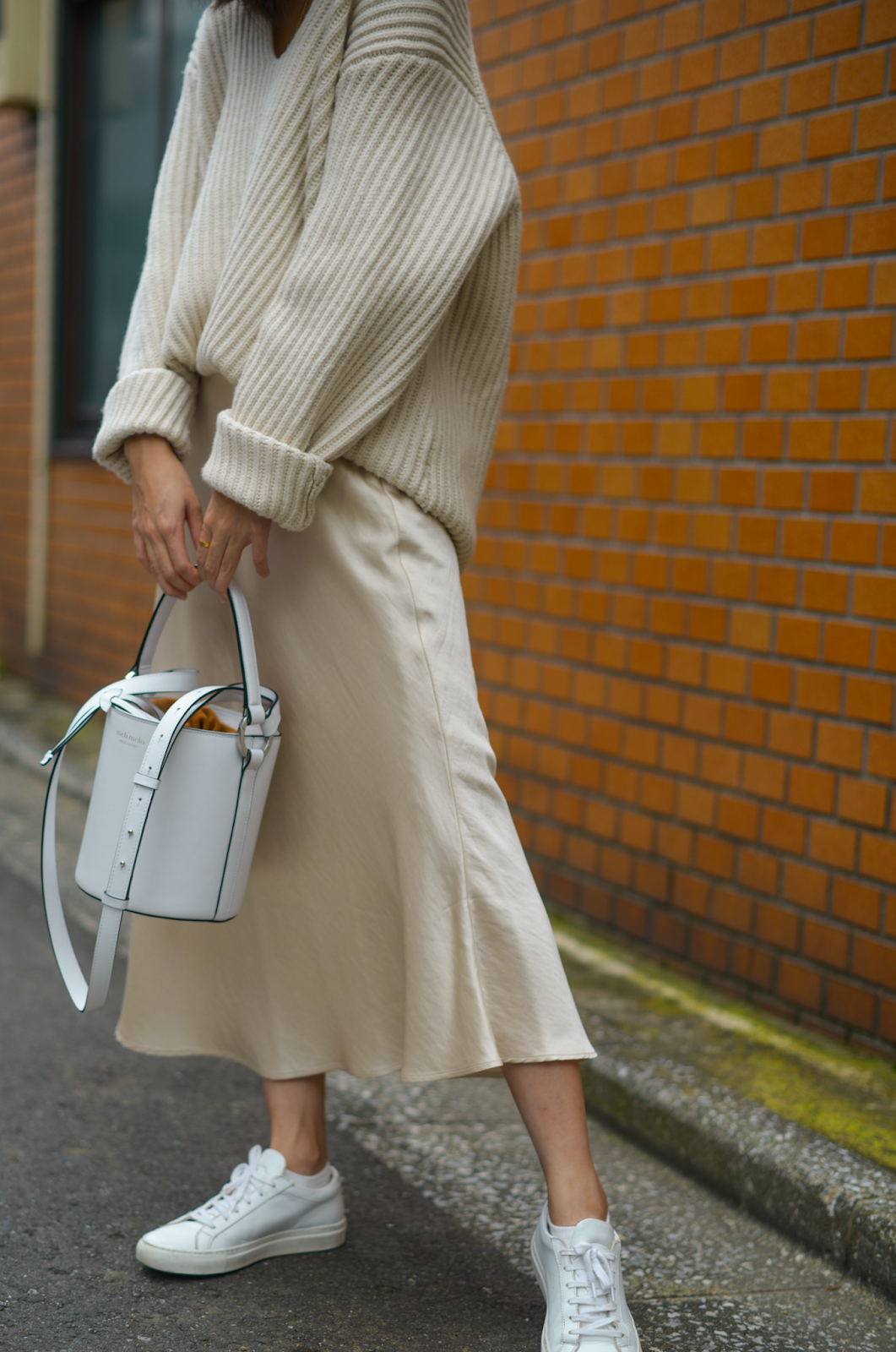 Chunky knit sweaters for fall, beige satin skirt and oversized sweater, satin skirt outfit ideas, long satin skirt outfit ideas for fall, winter white outfits, monochromatic white outfits, Meli Melo Santina bucket bag, white bucket bag outfit ideas, street style, FOREVERVANNY style - Acne Studios Ribbed Wool Sweater Two Ways / FOREVERVANNY