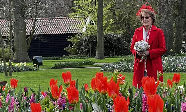 Dutch Princess Margriet is wearing a red wool coat by Max Mara, and red earrings. Garden of Europe or Keukenhof park