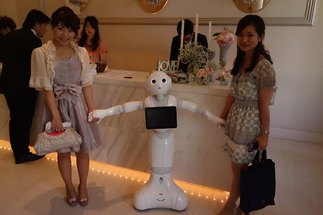 結婚式の受付で列席者と写真撮影するPepper