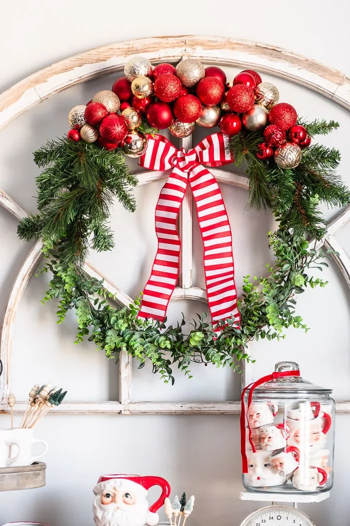 red and gold ornament clusters, greenery wreath, striped ribbon