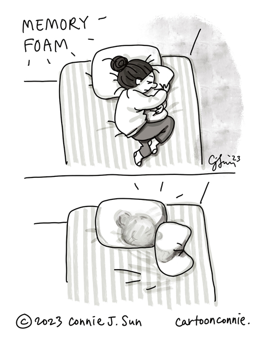 2-panel autobio comic of a cartoon girl with a bun, sleeping on memory foam pillows. Panel 1: Overhead view of the girl, laying on her side, with her head on one pillow and hugging another pillow, like it's a teddy bear. Panel 2: Overhead view of the bed, with just the pillows, one with the indentation of her profile, the other misshapen from being squeezed. Cartoon illustration by Connie Sun, cartoonconnie, 2023.