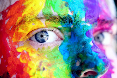 A face with body paint in chaotic colors